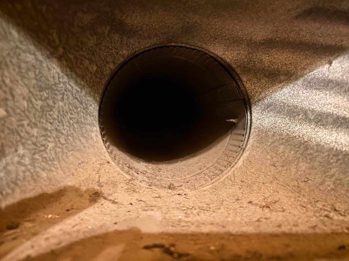 Duct boot with a layer of dust around the round duct opening